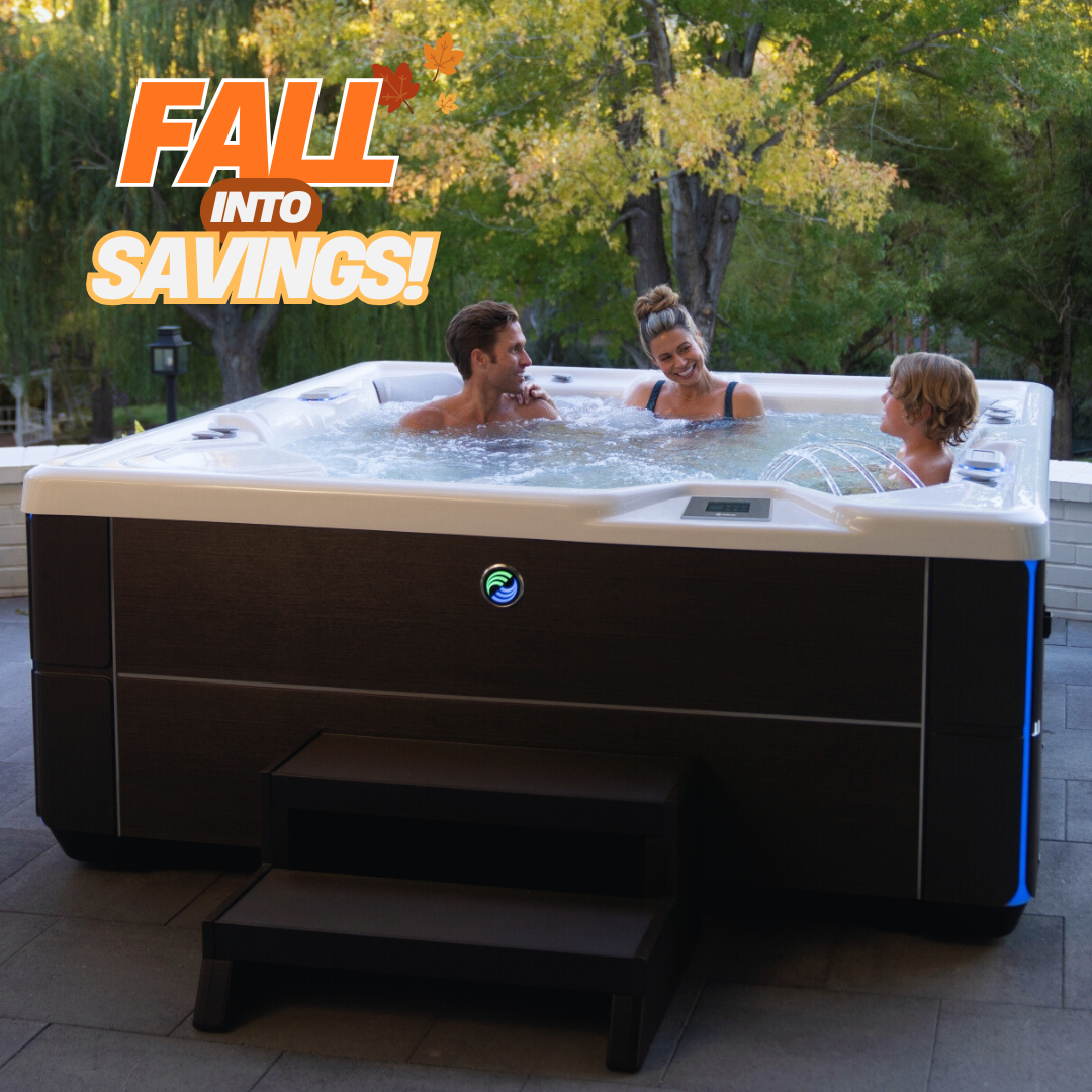 A large outdoor hot tub with three people relaxing in the water, set on a patio with trees in the background. Large promotional text in the top left reads 'FALL INTO SAVINGS!'.