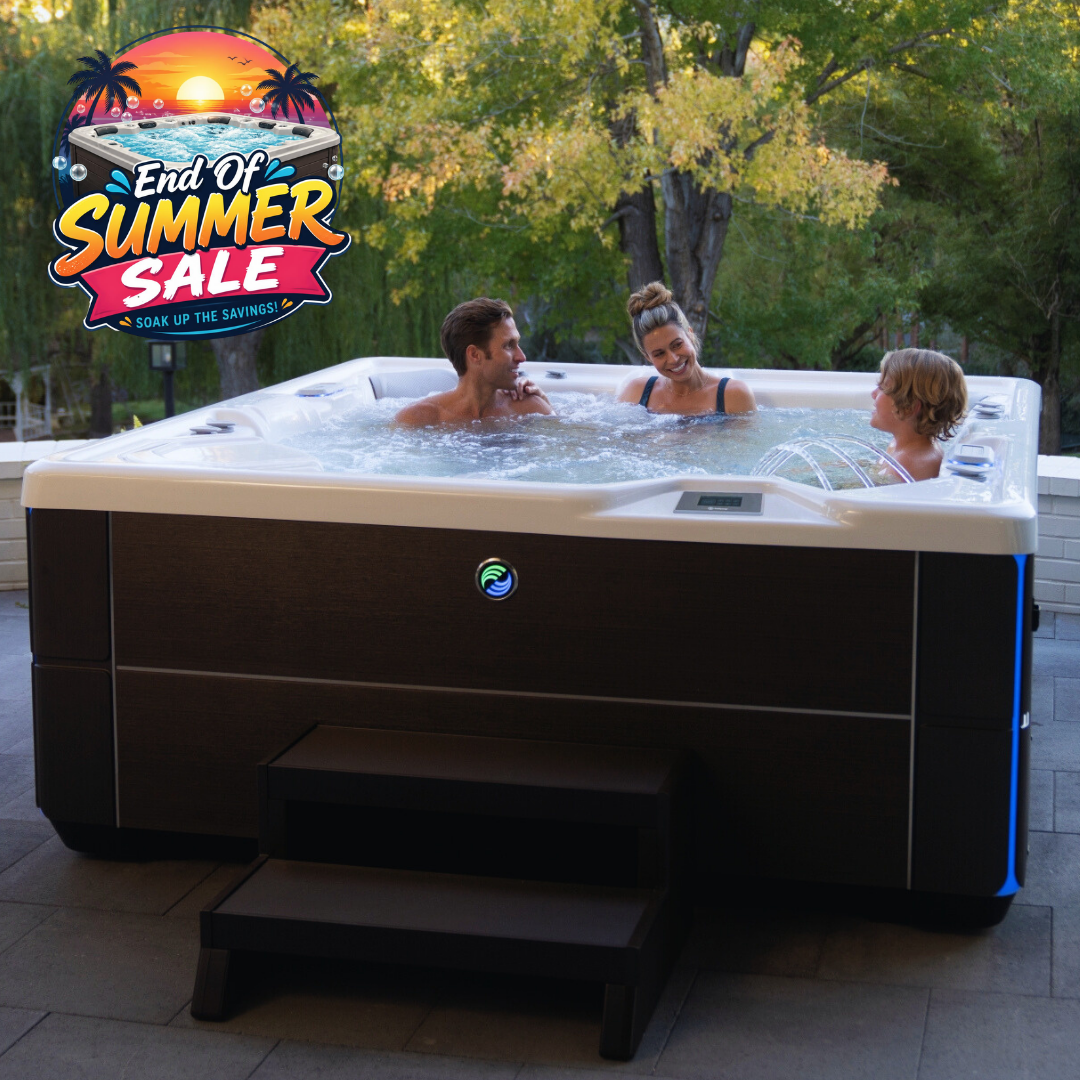 A large outdoor Hot Spring hot tub with three people relaxing in the water, set on a patio with trees in the background. A colorful 'End Of Summer Sale' graphic overlay is visible in the top left corner.
